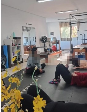Interior do Studio Pilates Tais Ariadne, com aparelhos e alunas em atividade